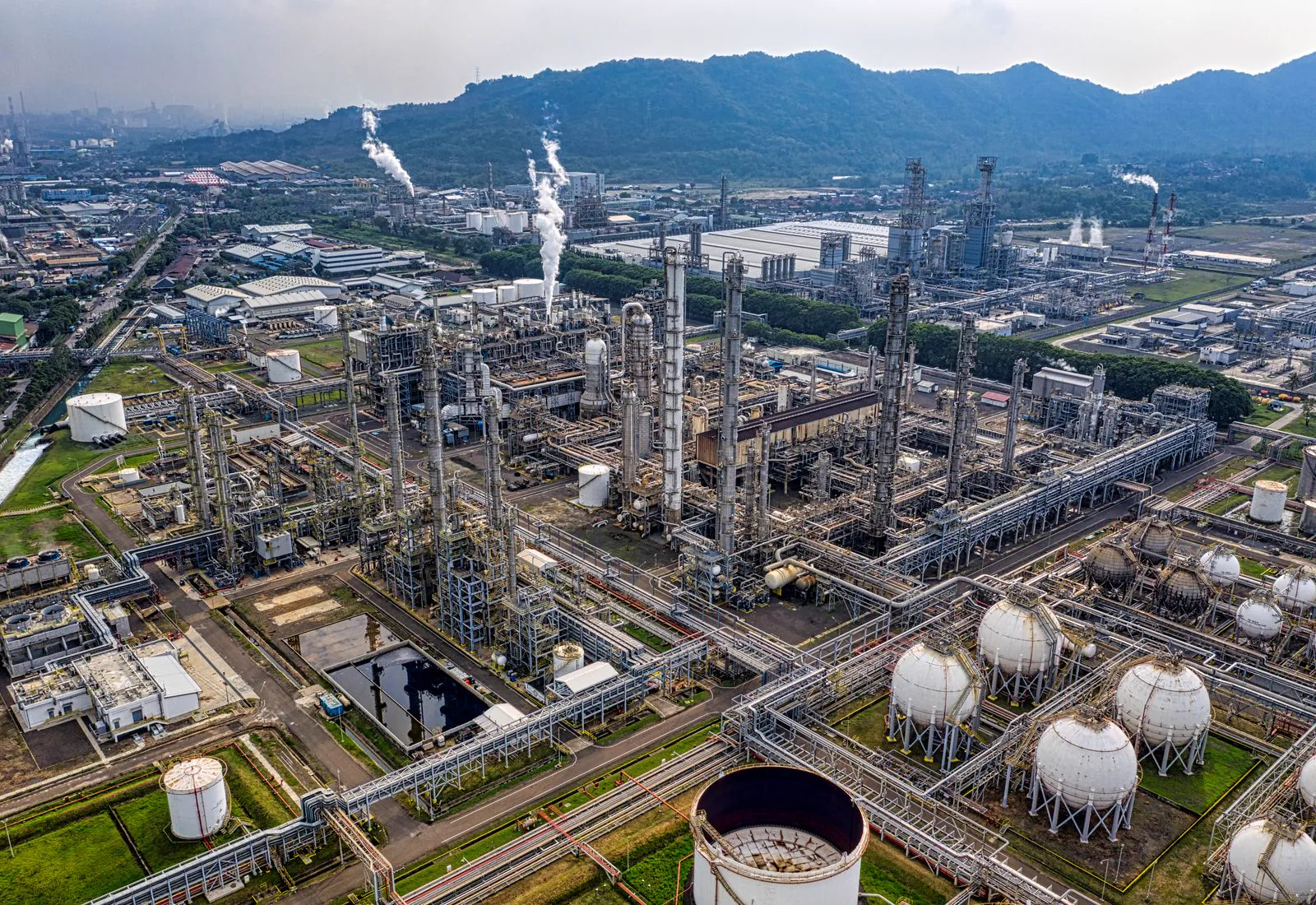 Aerial view of a large oil refinery with storage tanks and pipework