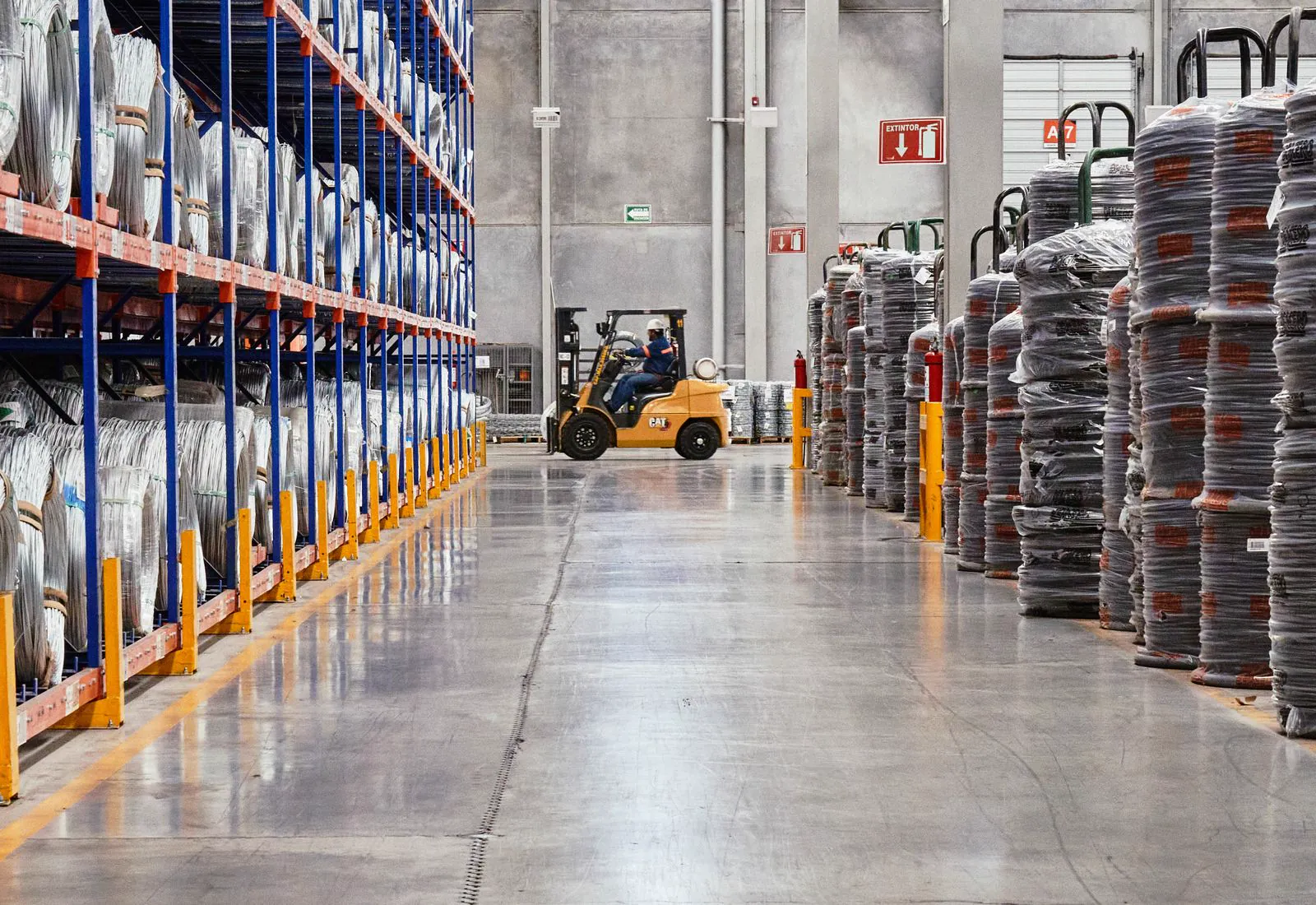 Warehouse aisle with racking stacked with pallets and goods