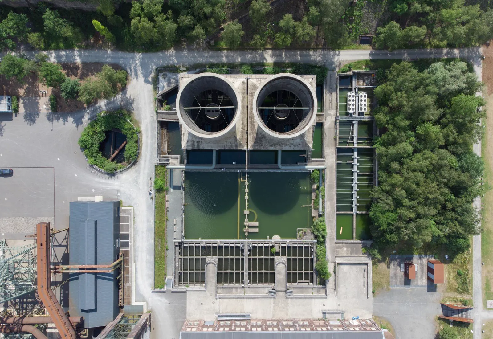 Aerial view of a water treatment plant with circular settlement tanks
